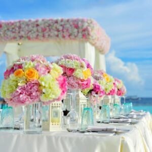 Beautiful seaside wedding setup with floral arrangements and pastel colors on a sunny day.
