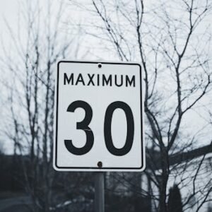 Photograph of a road sign indicating a maximum speed limit of 30 in a winter setting.