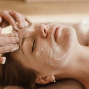 A close-up of a woman receiving a soothing facial massage with a skincare mask.