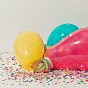 Vibrant colorful balloons surrounded by confetti, perfect for party celebrations.